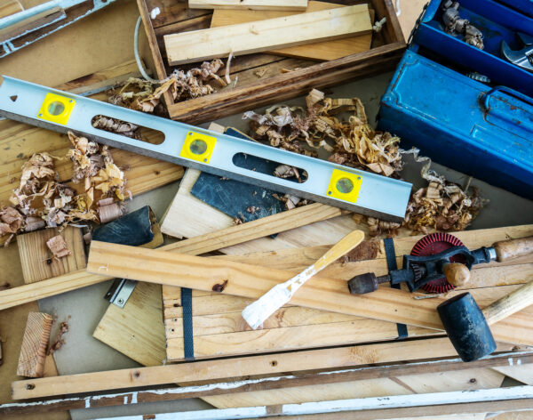 Background image of carpenters workstation, carpenters work table with different tools, wood cutting, water level gauge with wood shavings