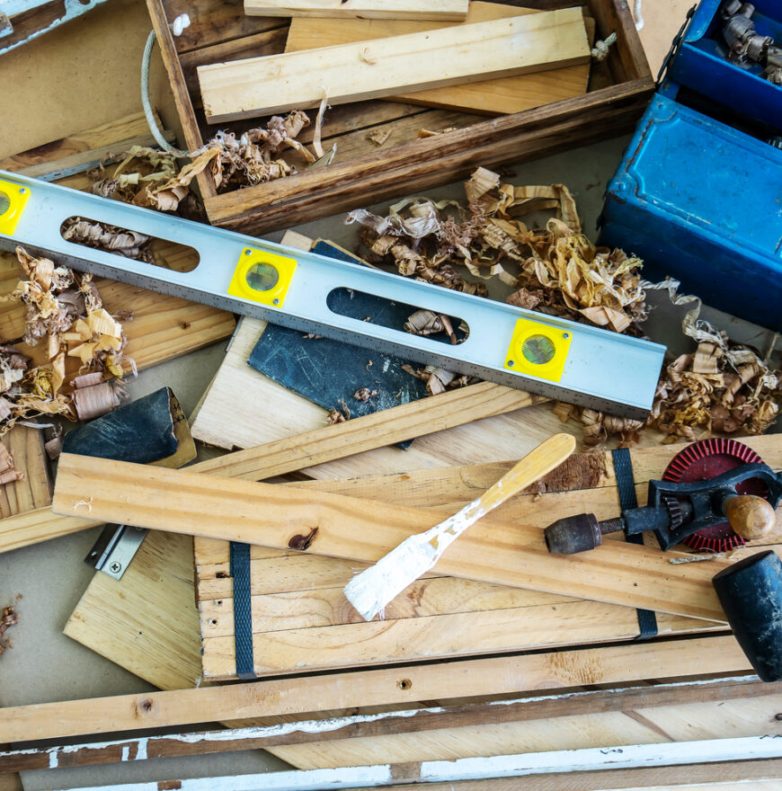 Background image of carpenters workstation, carpenters work table with different tools, wood cutting, water level gauge with wood shavings